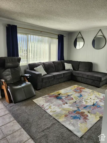 Large window with vertical blinds, carpeted flooring, and panelled walls