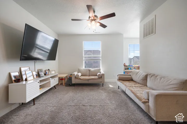 Neutral wall color palette, carpeted flooring, dual pane windows, and ceiling fan with integrated lighting