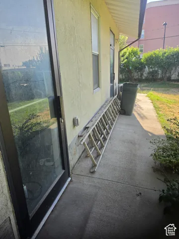 Stucco exterior finish with a concrete patio and sliding glass door