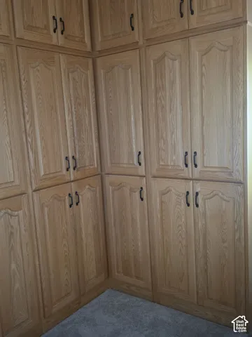 Floor-to-ceiling wooden cabinetry featuring arched paneling and dark hardware