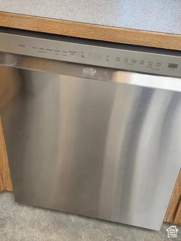 Stainless steel dishwasher with digital control panel and wood-finish cabinetry
