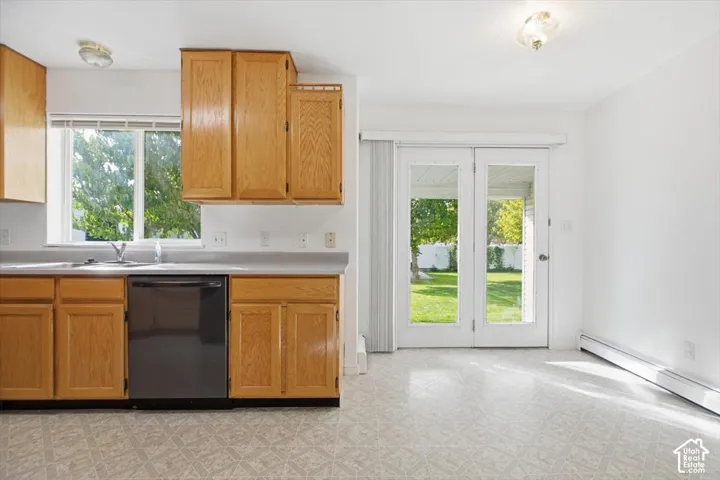 Kitchen featuring shaker-style wood cabinetry, neutral countertops, a built-in dishwasher, and double glass-panel doors