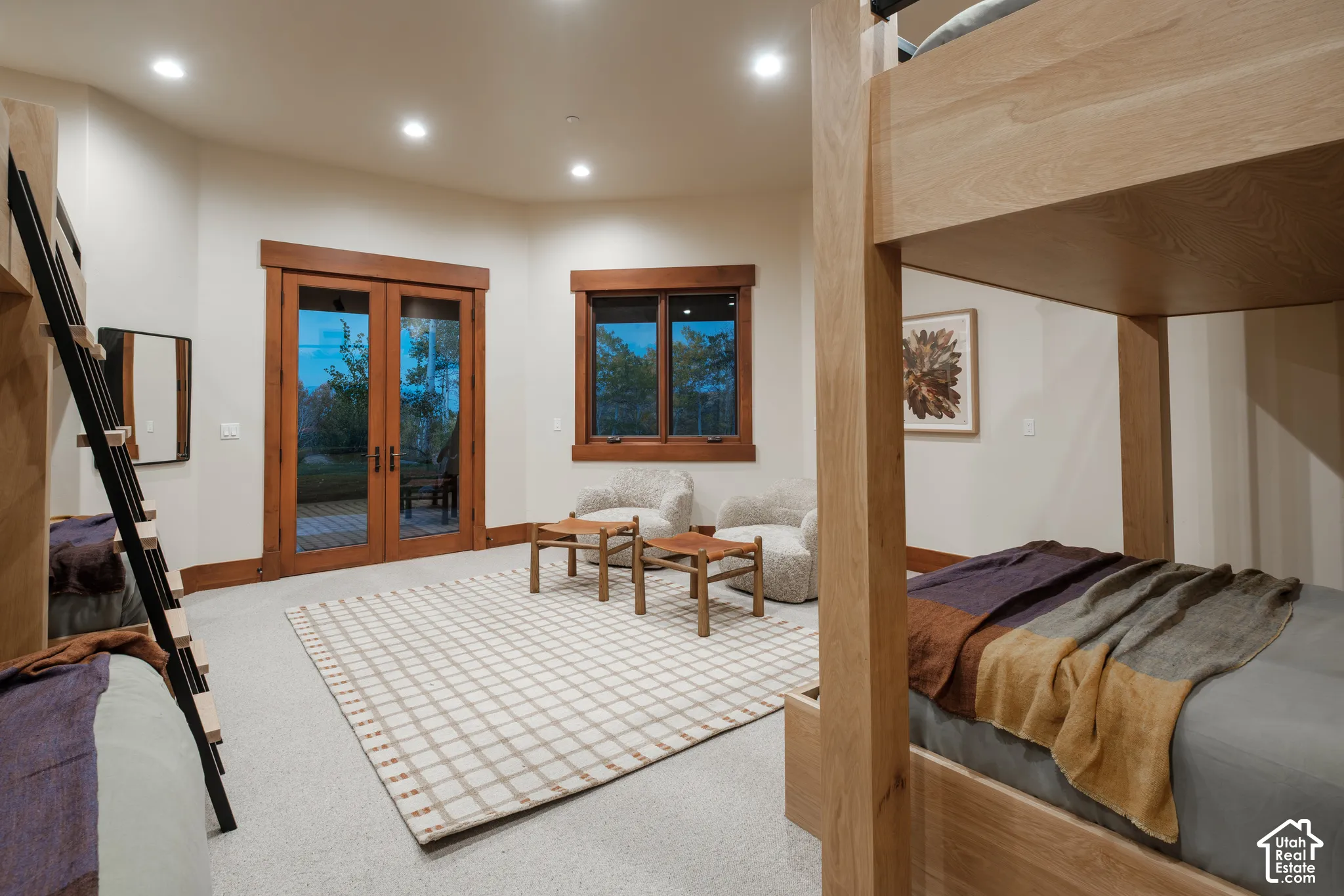 Spacious room featuring custom built-in wood bunk beds, recessed lighting, expansive glass-paned double doors, and wood-trimmed windows