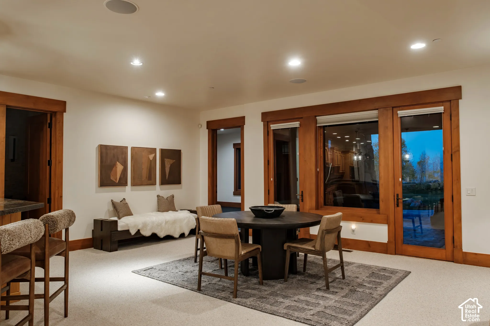 Living area featuring natural wood-finish door and window casings, recessed lighting, and integrated ceiling speakers