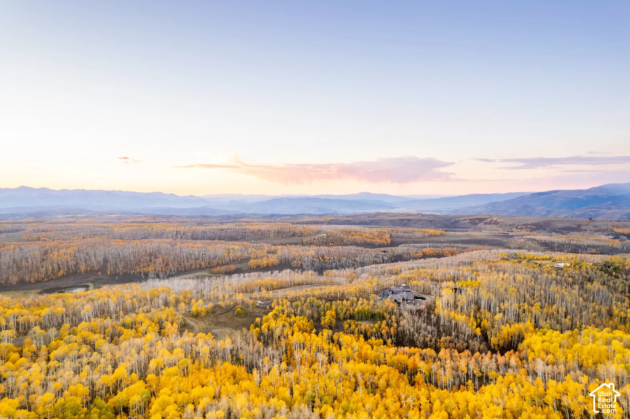 Expansive property grounds surrounded by mature aspen forests and mountainous terrain