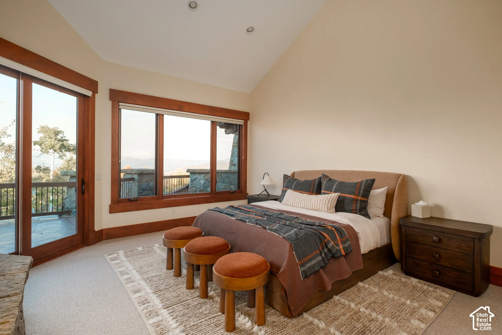 Vaulted ceiling, large windows with natural wood trim, sliding glass door, and recessed lighting