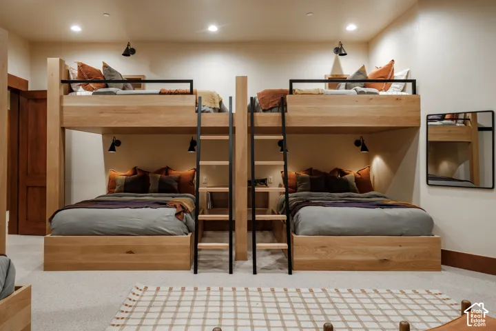 Custom built-in wood bunk units featuring integrated ladders, recessed lighting, and matte black metal guardrails