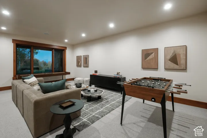 Recessed lighting, oversized window with natural wood trim, and wall-to-wall carpeting