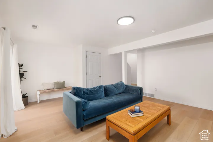 Interior space featuring neutral wall paint, wood-finish flooring, a flush-mount circular ceiling light, and a white six-panel interior door