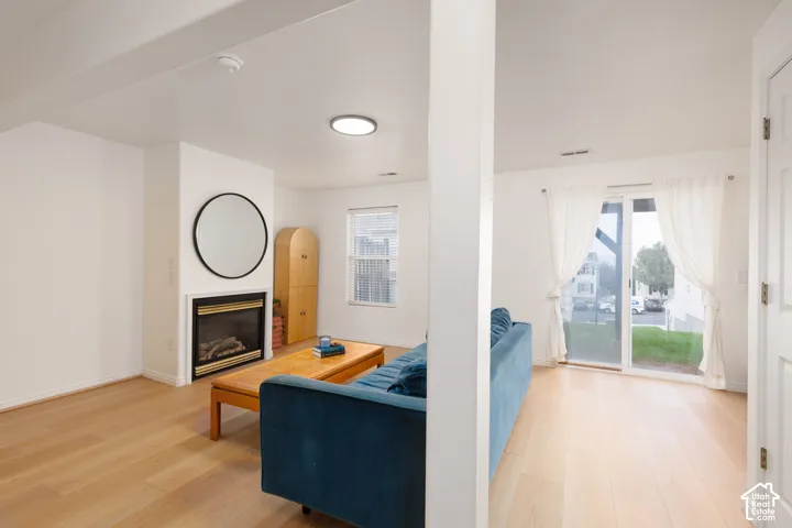 Interior space featuring wood-finish flooring, a fireplace with a black surround, sliding glass doors, and recessed lighting