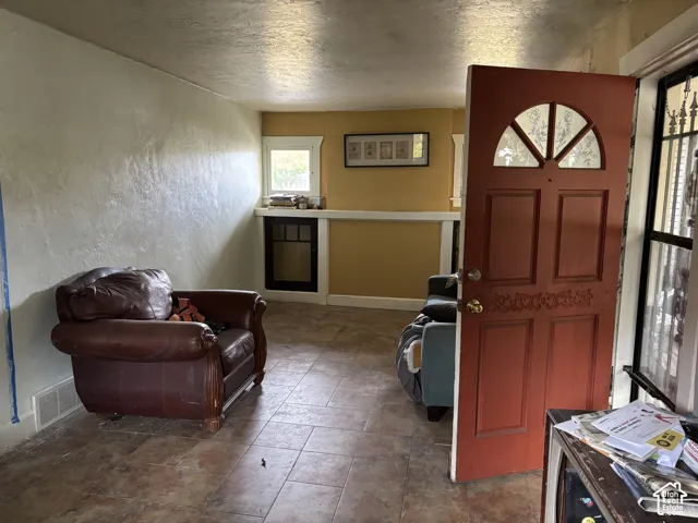 Tile flooring, recessed built-in shelving, multi-pane window detail, and an arched-top wooden entry door