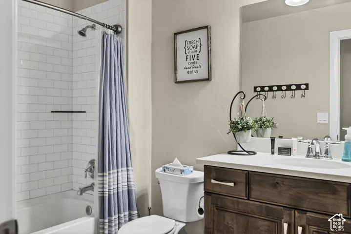 Bathroom featuring white subway tile shower surround, vanity with dark wood-finish cabinetry, solid surface countertop, and large wall-mounted mirror