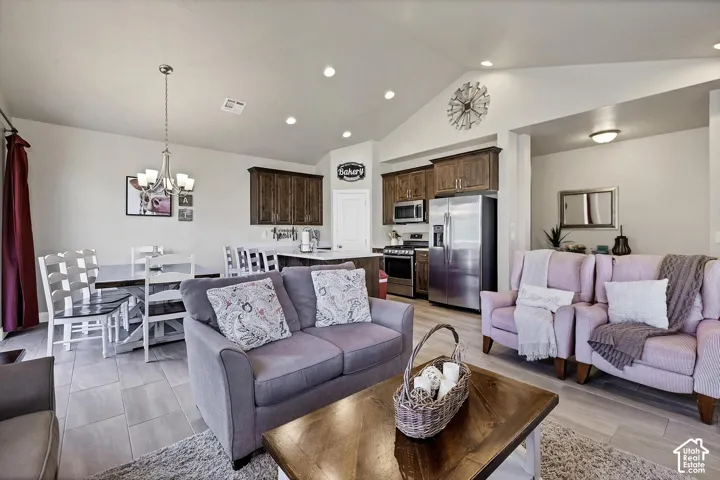 Vaulted ceilings, recessed lighting, tile flooring, stainless steel kitchen appliances, and wood-finish cabinetry
