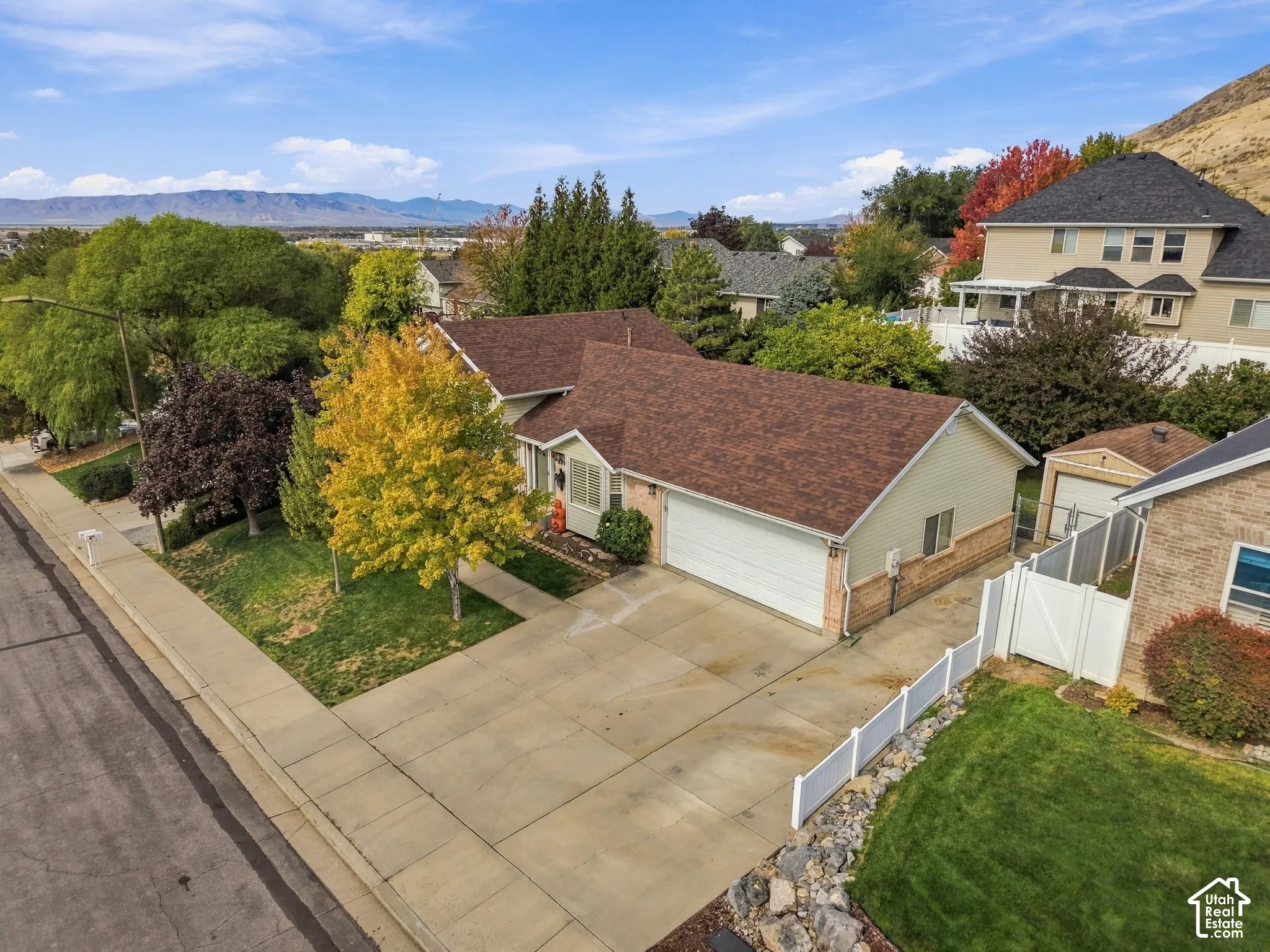 Single-story residence featuring a two-car attached garage, concrete driveway, stone and vinyl siding exterior, and a mountain backdrop