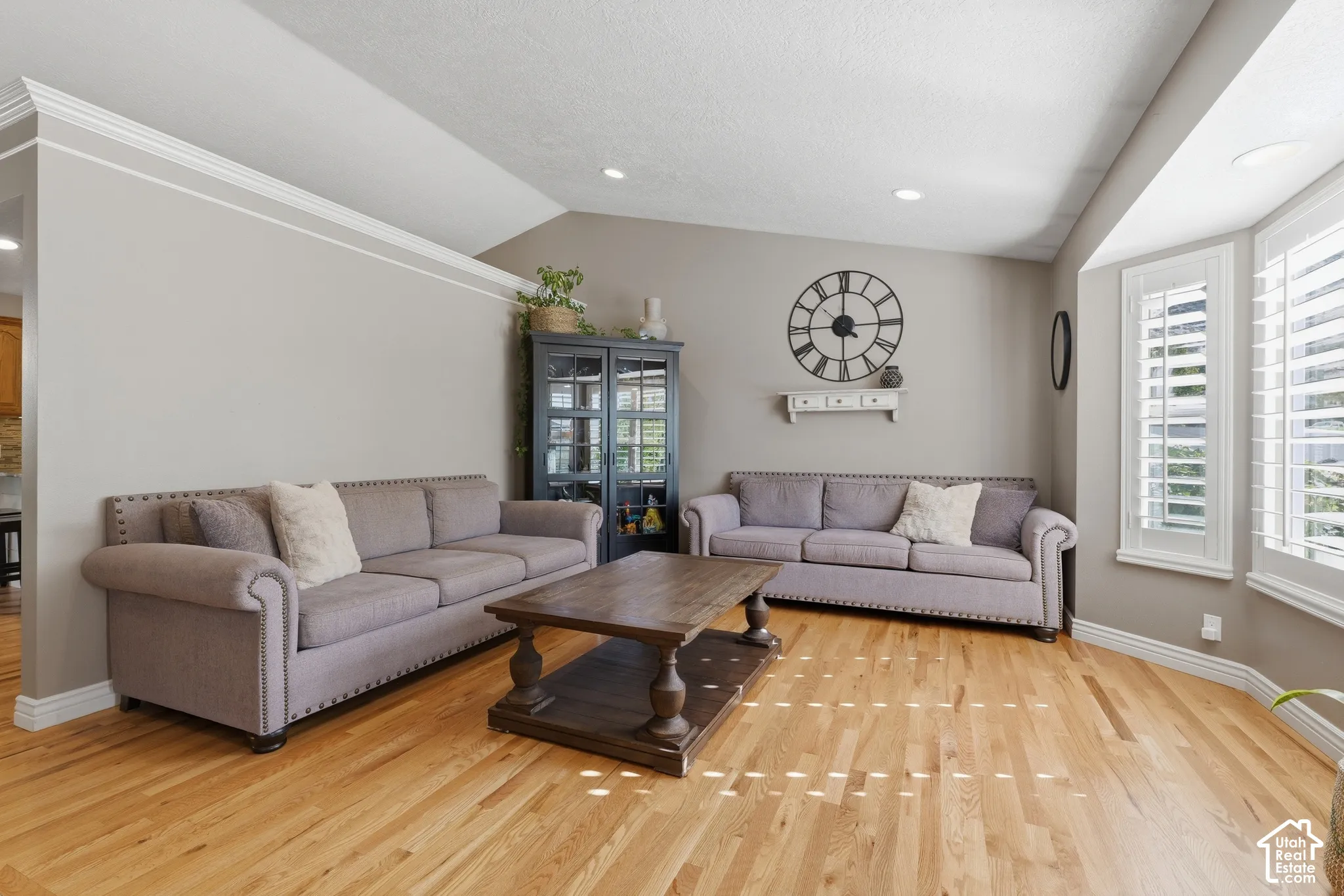 Vaulted ceilings, wood-finish flooring, recessed lighting, and bay window featuring plantation shutters