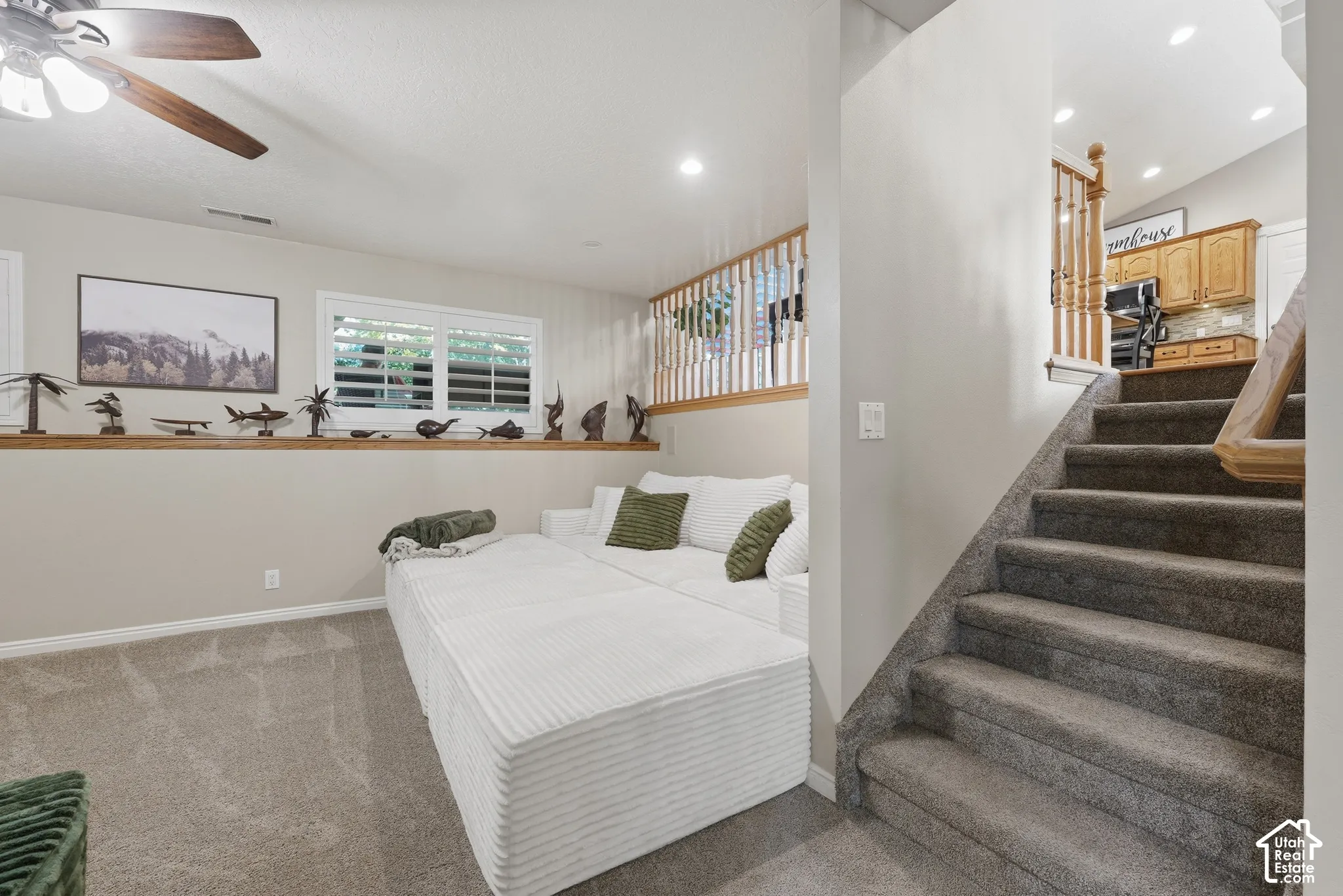 Interior space featuring wood-finish railings, recessed lighting, carpeted flooring, and a window with plantation shutters