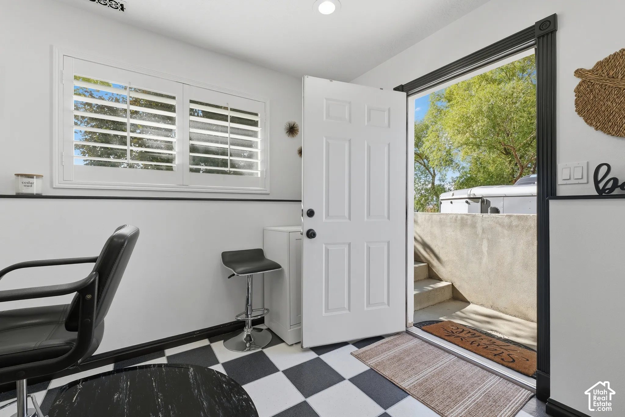 Entryway featuring checkered flooring, recessed lighting, plantation shutters, and a paneled door with contrasting dark trim