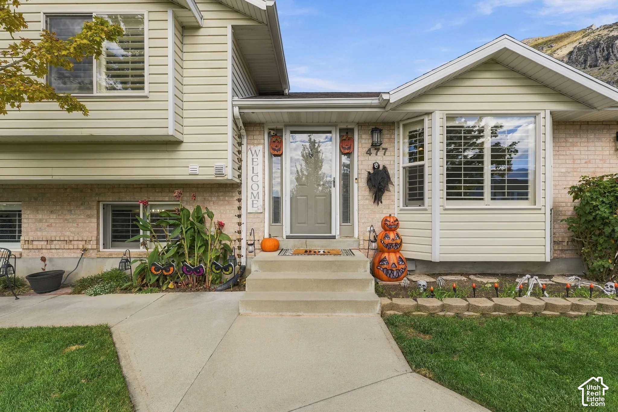 Split-level exterior featuring light brick masonry, horizontal siding, a covered entryway, and a prominent bay window
