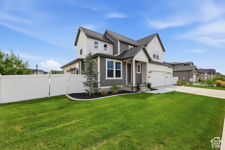 Two-story exterior featuring vertical and horizontal siding, a multi-gabled roofline, a multi-car garage, and a white privacy fence