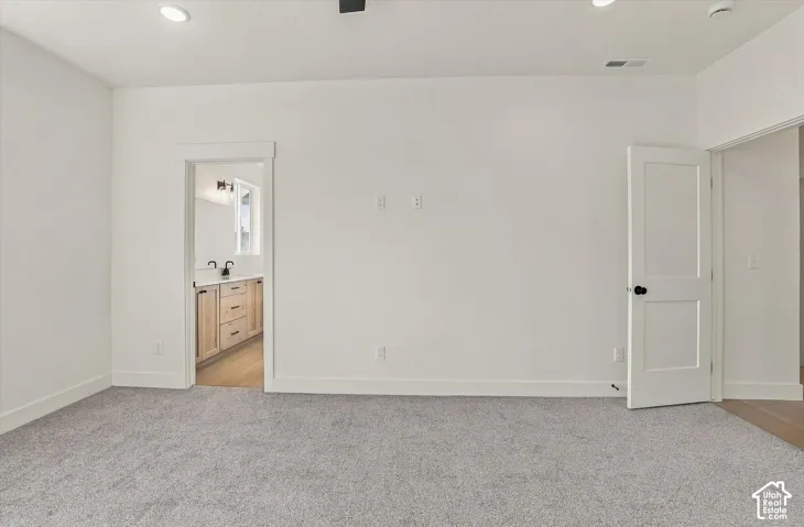 Neutral-toned carpeting, recessed ceiling lighting, and solid-core interior doors with matte black hardware