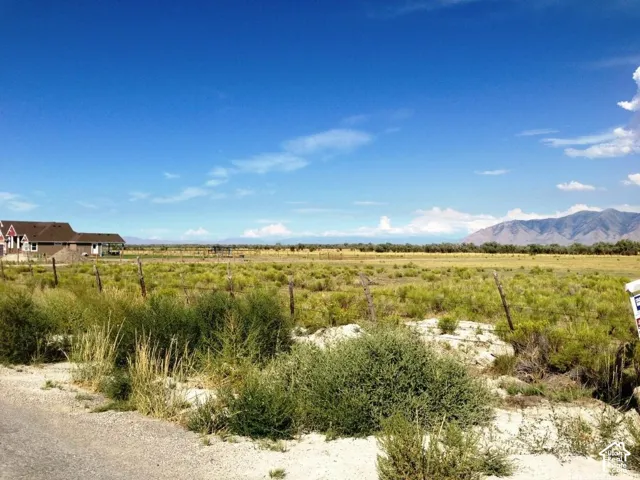 Expansive lot featuring native terrain, perimeter post-and-wire fencing, and mountain scenery