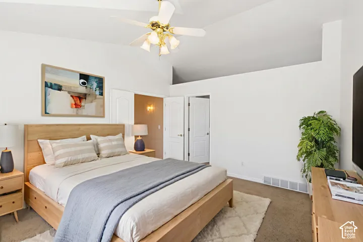 Vaulted ceilings, brass-finished ceiling fan with integrated lighting, and dual interior doors with arch-top detailing