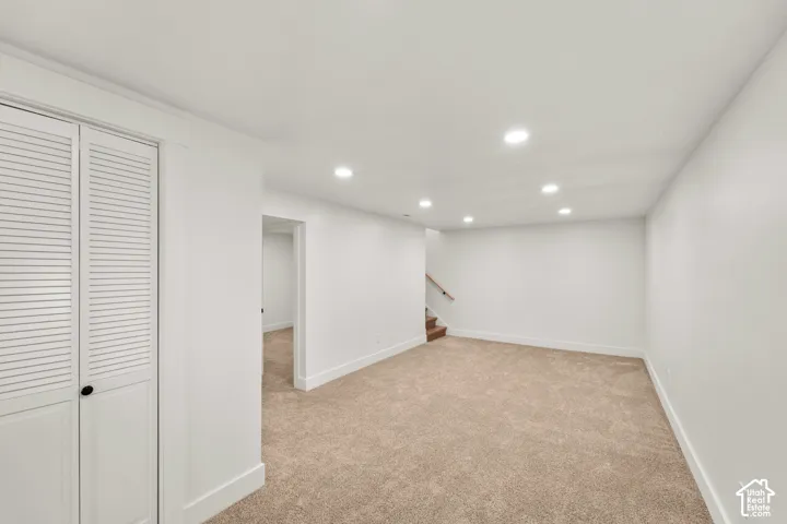 Neutral interior space featuring recessed ceiling lighting, wall-to-wall carpeting, and floor-to-ceiling closet with louvered doors