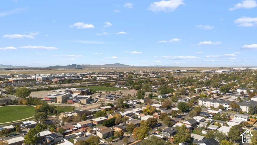 Aerial perspective of the surrounding residential landscape featuring prominent mountain scenery and expansive sky