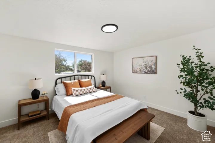 Neutral-toned carpeting, crisp white walls, and a large window featuring natural light