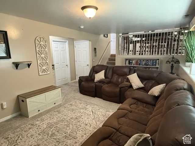 Neutral interior space featuring carpeted flooring, built-in shelving, two interior doors, and a staircase with white vertical railings