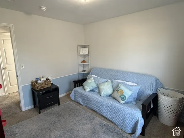 Room featuring wall-to-wall carpeting, two-tone paint with chair rail molding, and a built-in corner shelving unit