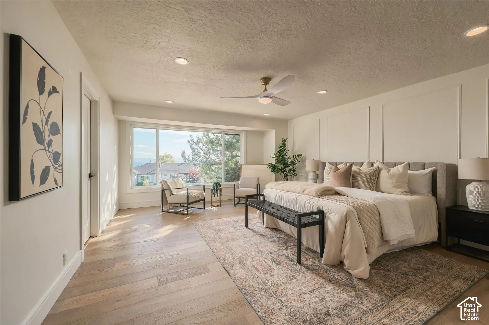 Spacious room featuring wood-finish flooring, recessed lighting, a modern ceiling fan, and intricate wall molding