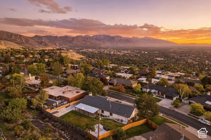 Aerial perspective featuring a sprawling landscape with prominent mountain silhouettes and a sunset horizon