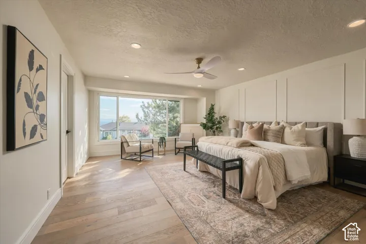 Spacious room featuring wood-finish flooring, recessed lighting, a modern ceiling fan, and intricate wall molding