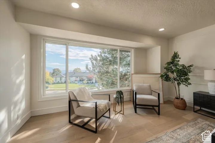 Large picture window with exterior scenery, recessed lighting, and wood-finish flooring