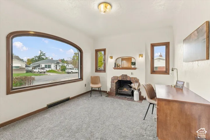 Large picture window with wood trim, masonry fireplace, built-in mantel, recessed wall niche, and flush-mount ceiling light fixture