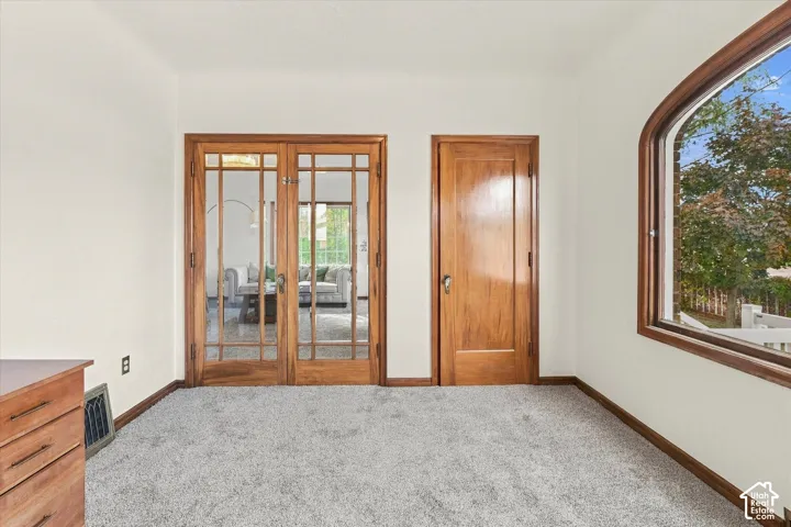 Wood-trim arched window, solid wood interior door, and French doors with glass panes