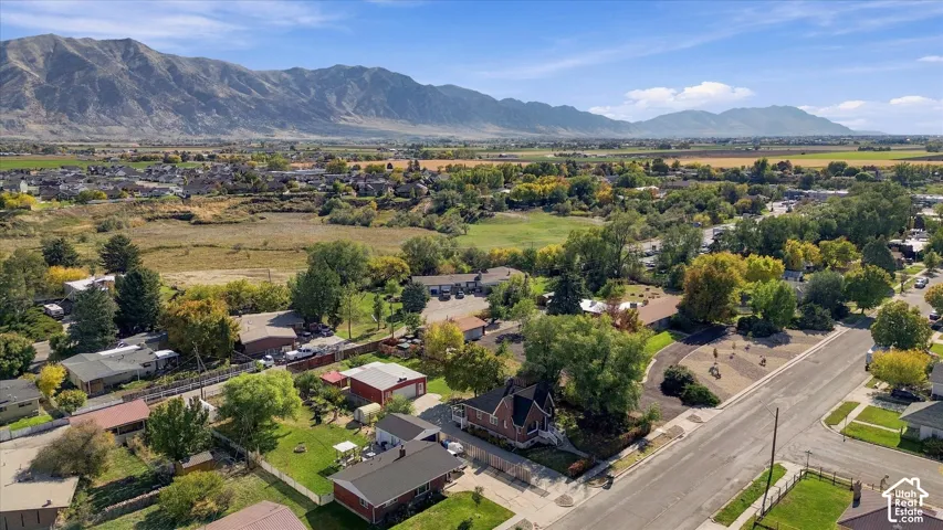Aerial perspective featuring expansive mountain scenery, mature trees, and established landscaping