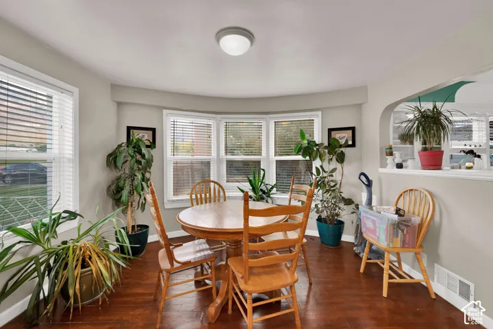 Bay window featuring multi-pane glass, wood-finish flooring, and a recessed archway opening