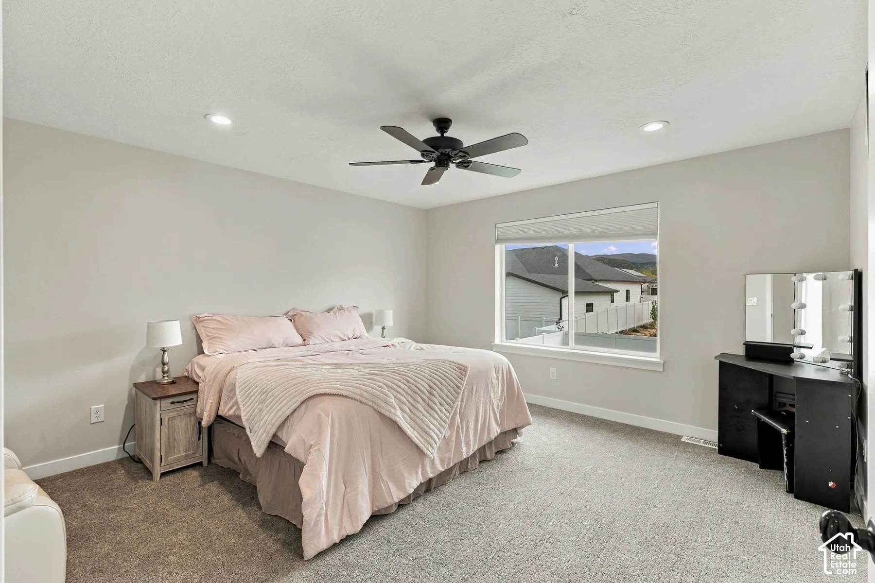 Neutral-toned interior featuring recessed lighting, a matte black ceiling fan, wall-to-wall carpeting, and a large window with mountain scenery