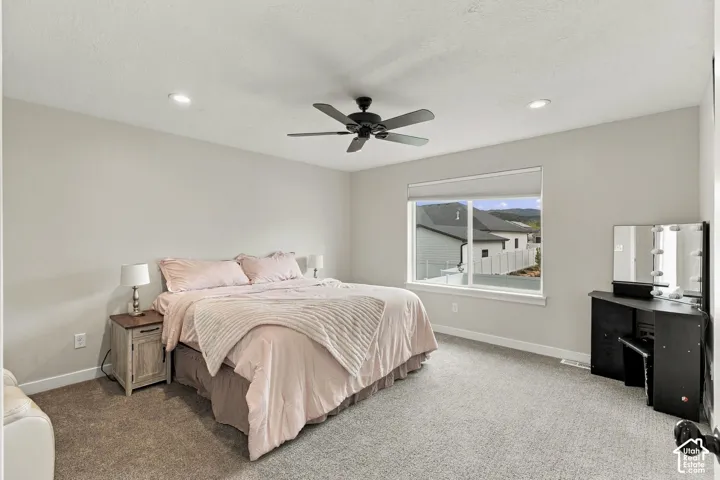 Neutral-toned interior featuring recessed lighting, a matte black ceiling fan, wall-to-wall carpeting, and a large window with mountain scenery