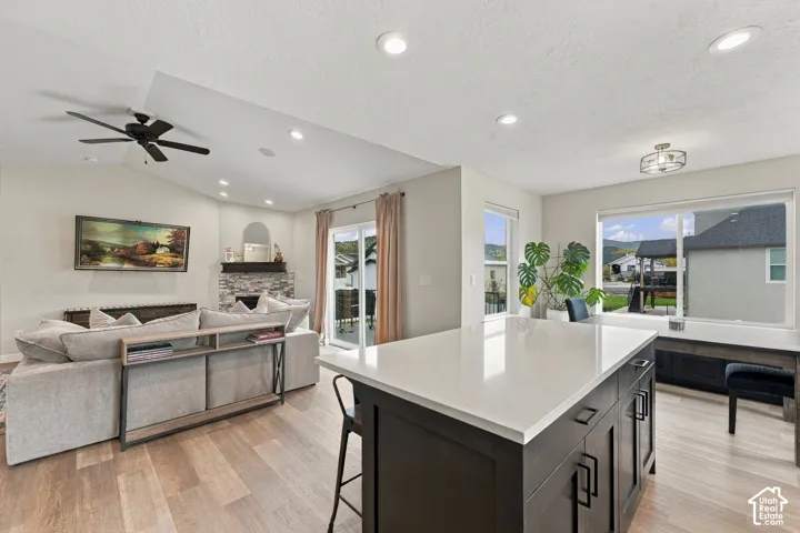 Open-concept space with vaulted ceilings, recessed lighting, and wood-finish flooring