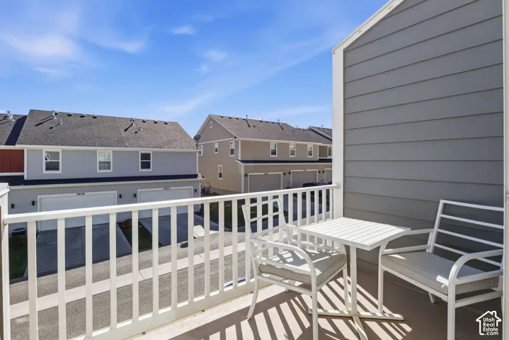 Kitchen walkout elevated balcony featuring a white metal railing and composite flooring