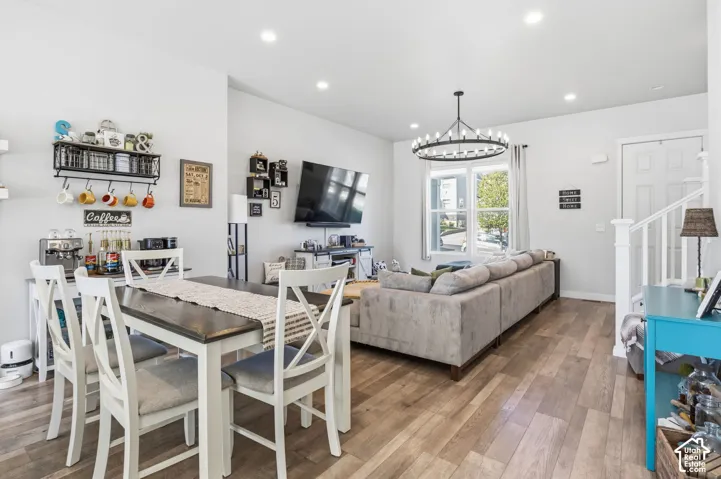 Open-concept interior featuring wood-finish flooring, recessed lighting, and a prominent circular chandelier