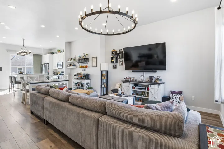 Open-concept interior featuring wood-finish flooring, recessed lighting, and a prominent circular chandelier