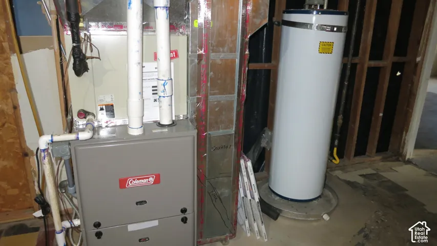 Coleman gas furnace with integrated metal ductwork, vertical white PVC venting, and a dedicated cylindrical water heater