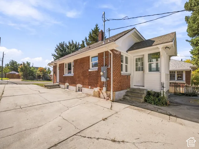 Exterior featuring red brick construction, white horizontal siding, a concrete driveway, and a gabled roofline