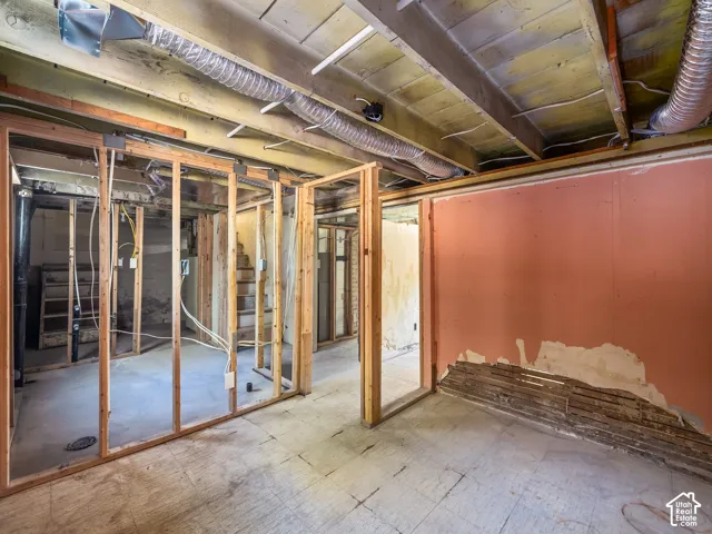Unfinished interior space featuring exposed wood framing, concrete flooring, exposed ceiling joists, and exposed ductwork