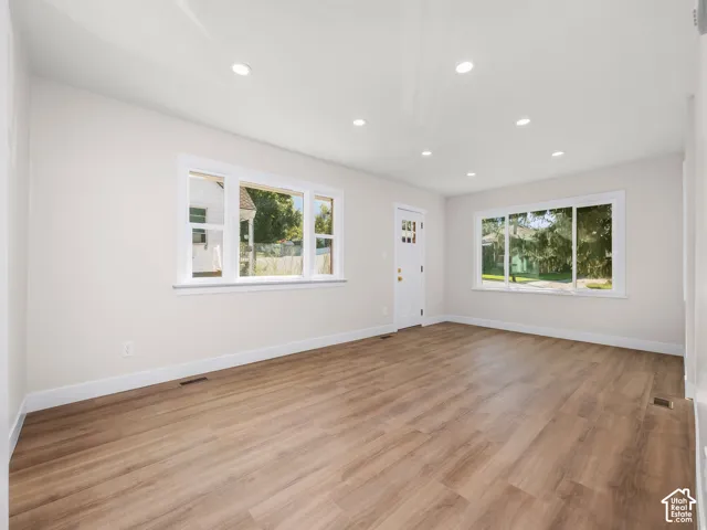 Open-concept interior featuring wood-finish flooring, recessed lighting, and large picture windows