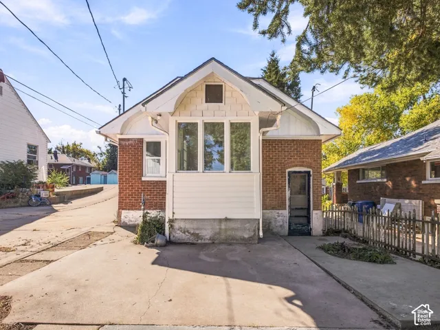Exterior featuring brick and shingle siding, concrete driveway, and triple-pane window bay